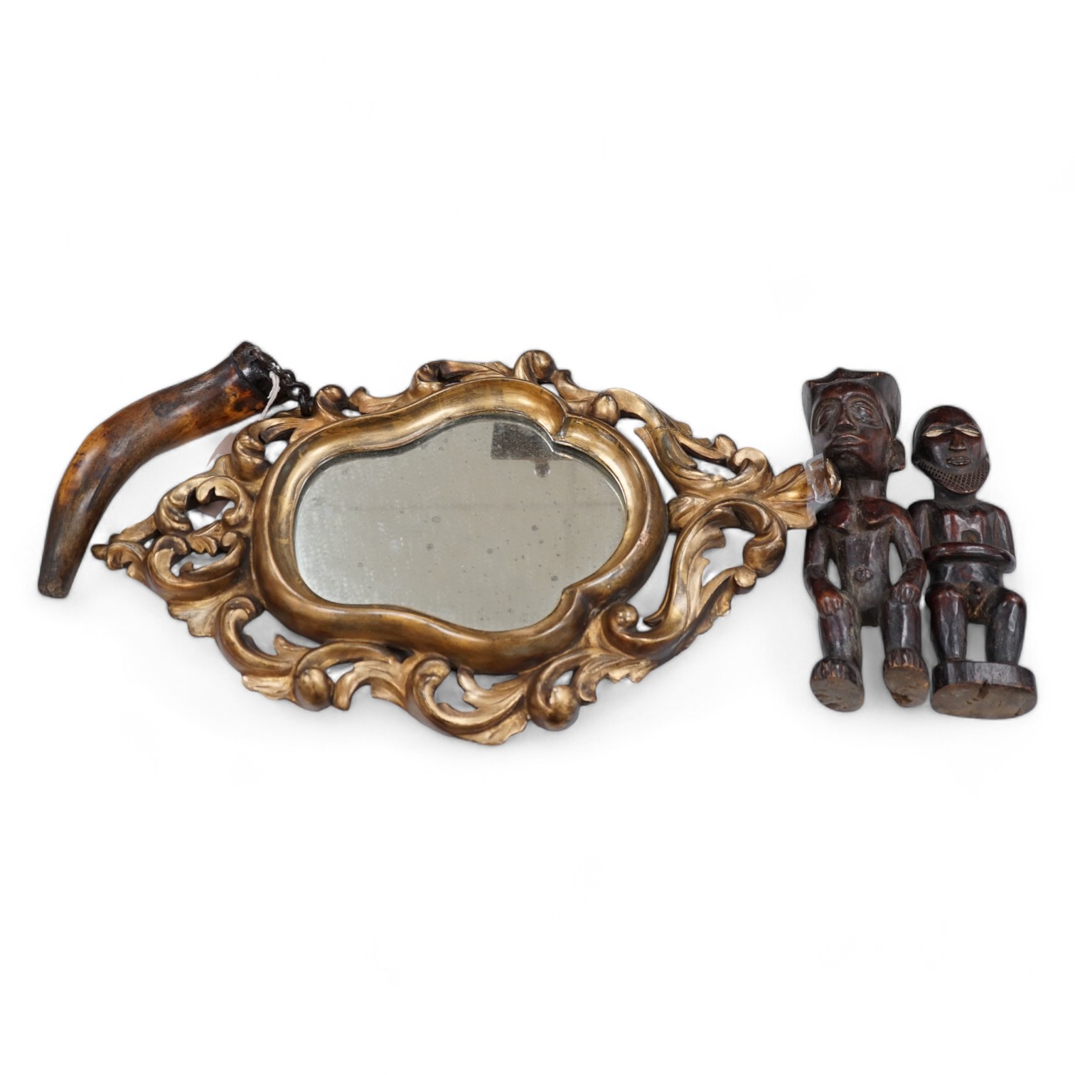 A 19th century giltwood mirror, a powder horn and a pair of tribal carved wood figures, mirror 55cm long. Condition - fair to good